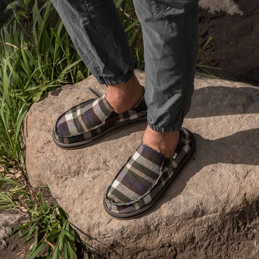 Close up of a person's feet wearing Sanuk 'Sidewalk Surfers Chill' shoes.